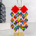 Colorful geometric pride earrings on a stand with a white background