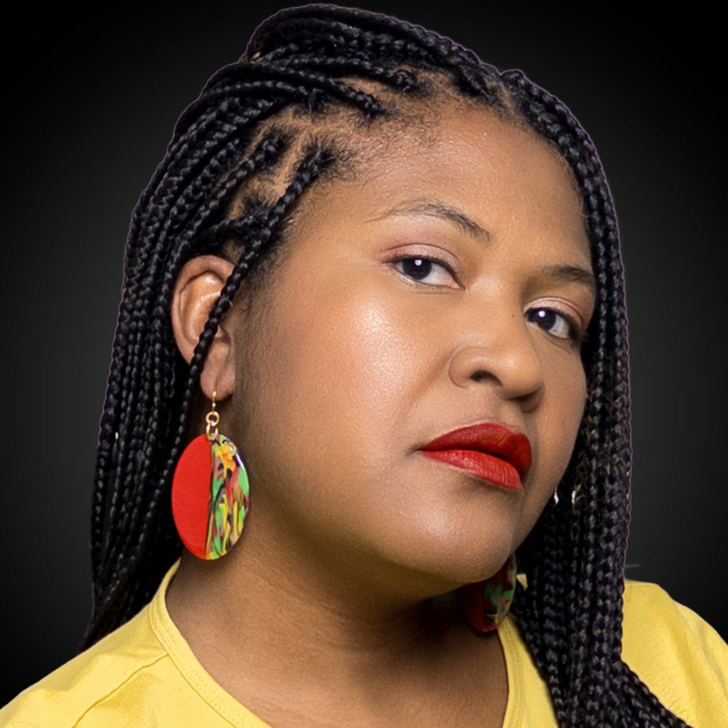 Woman with braided hair wearing black history month juneteenth black red green yellow abstract large statement dangle lightweight multicolored festive earrings