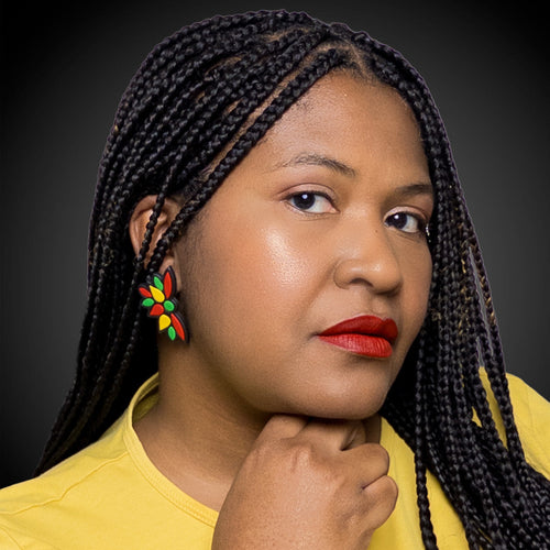 Woman with braided hair wearingblack history month juneteenth black red green yellow abstract large statement lightweight multicolored festive stud earringsbackground