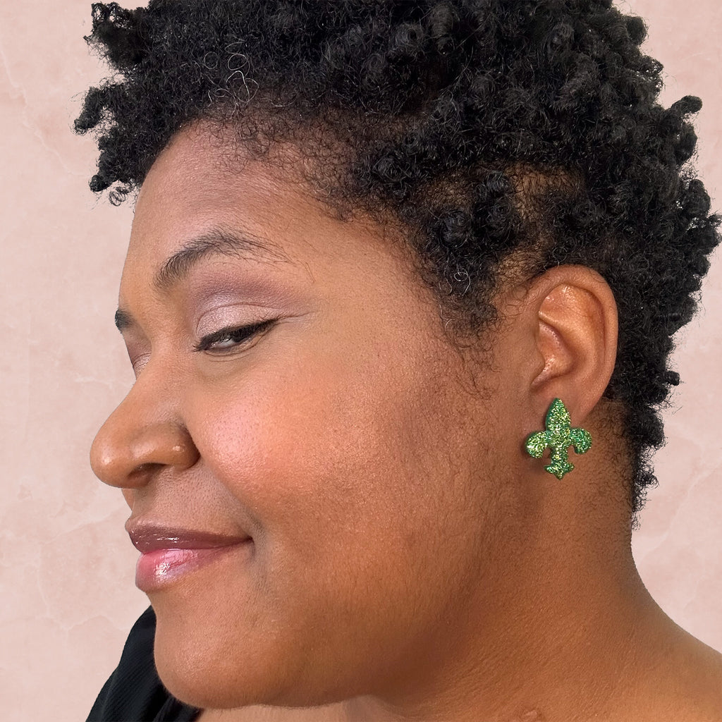 stunning statements clay mardi gras lightweight large big statement glitter shiny purple green gold fleur de lis stud earrings on a model