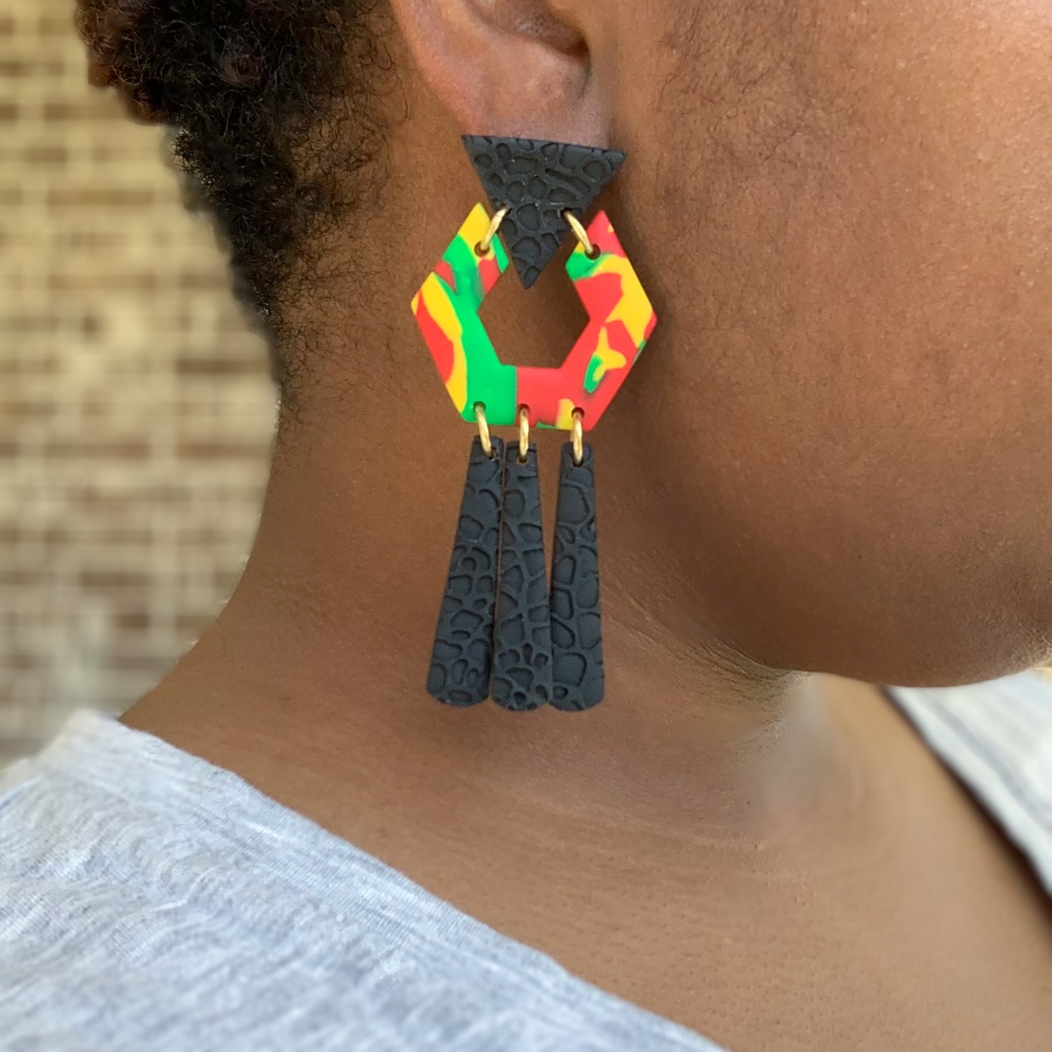 black history month juneteenth black red green yellow abstract large statement dangle lightweight multicolored festive earrings on a model