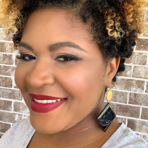 large metal and square dangle statement glossy clay earrings on a model